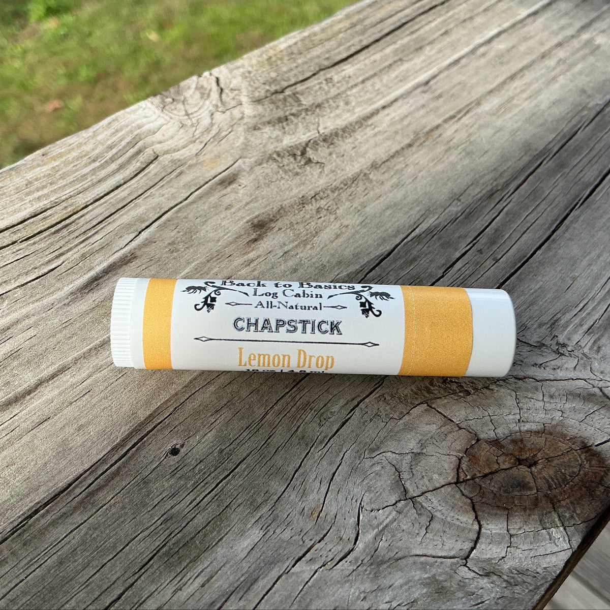 Chapstick stick on a wooden surface with a natural background