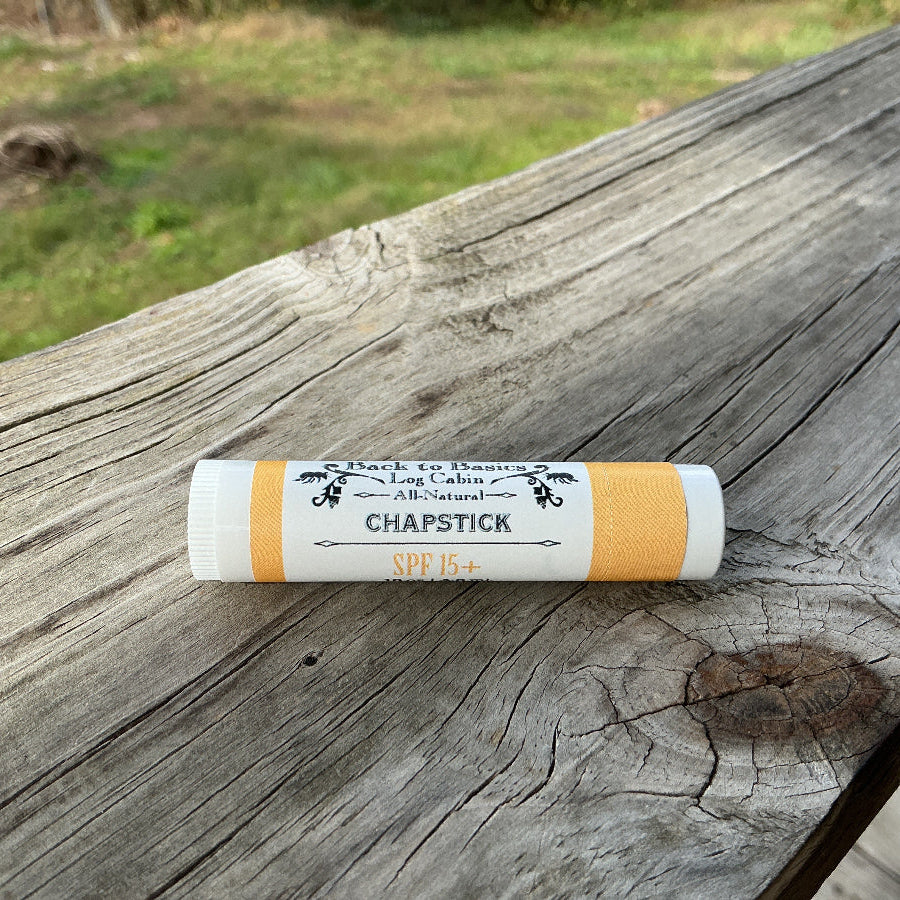 Chapstick tube on a wooden surface with a blurred natural background