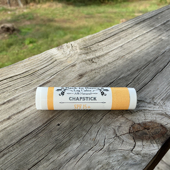 Chapstick tube on a wooden surface with a blurred natural background