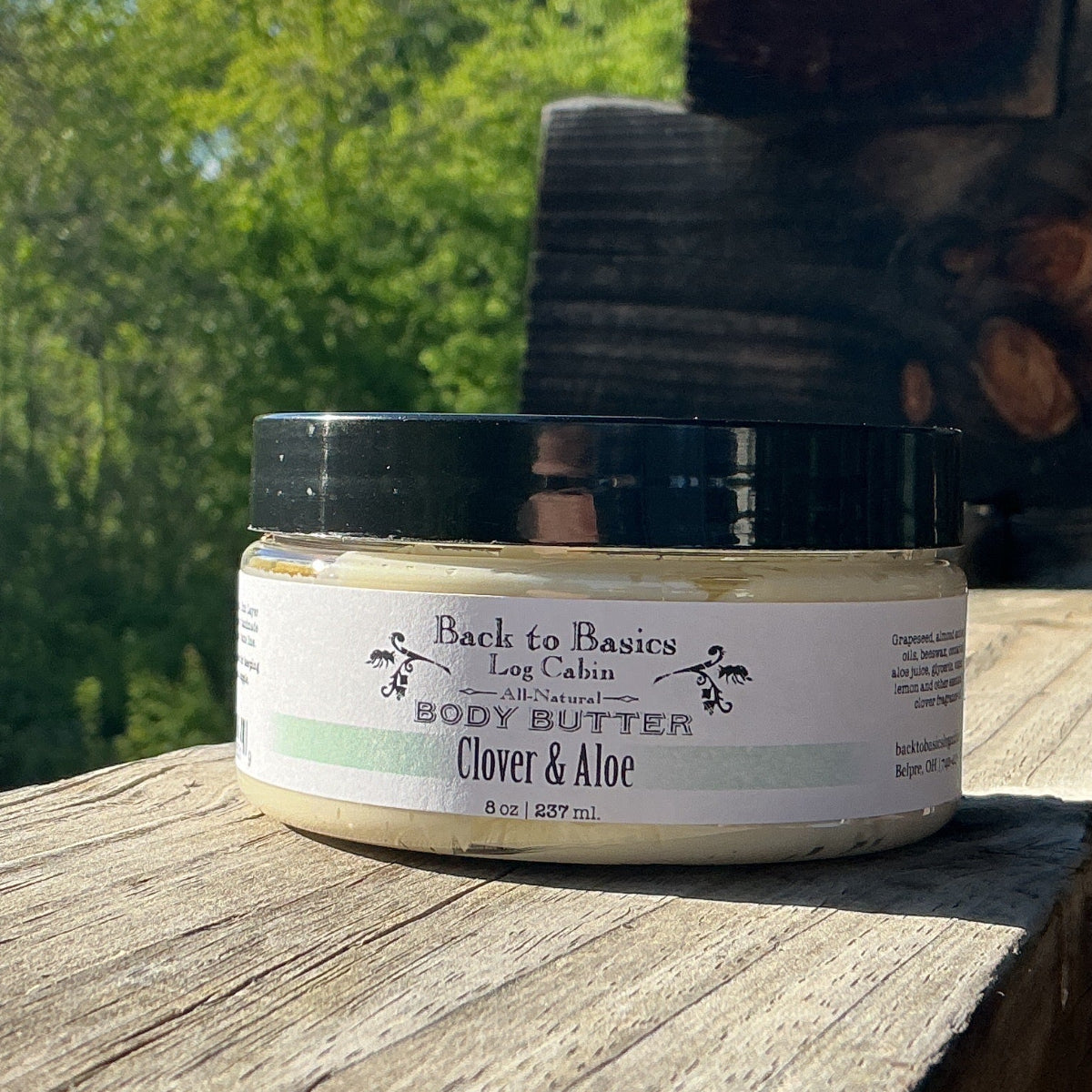 Jar of body butter on a wooden surface with a natural background
