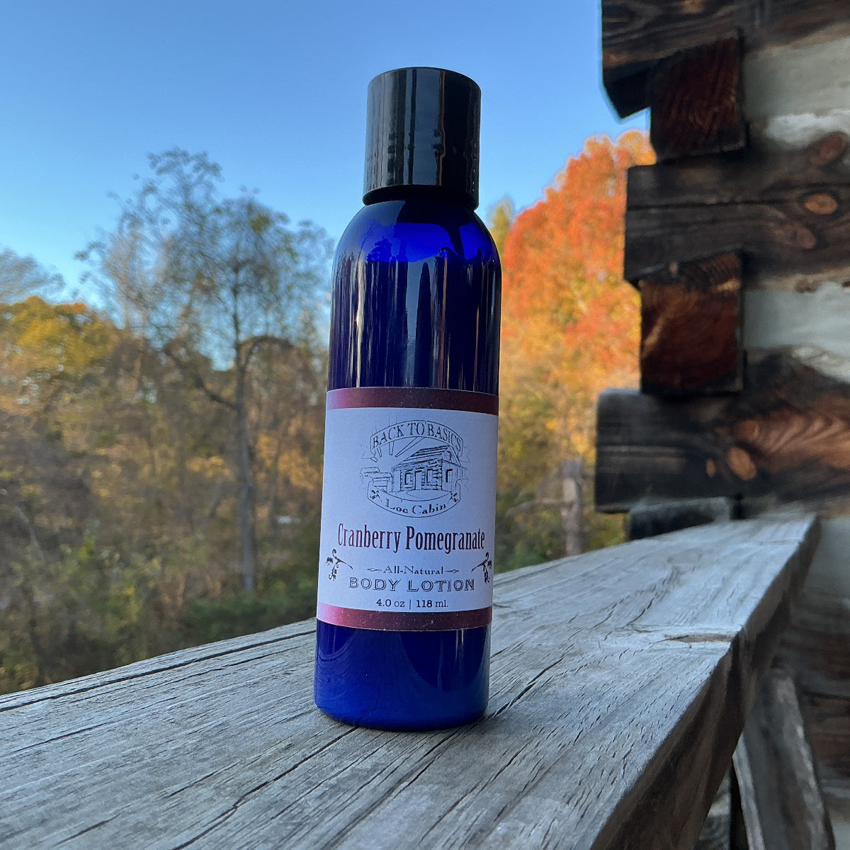Blue bottle of body lotion with a label on a wooden surface outdoors