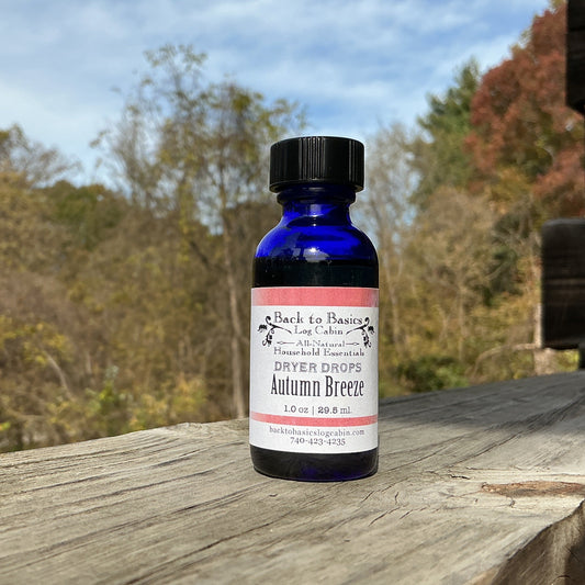 Bottle of Back to Basics Autumn Breeze on a wooden surface with a scenic background