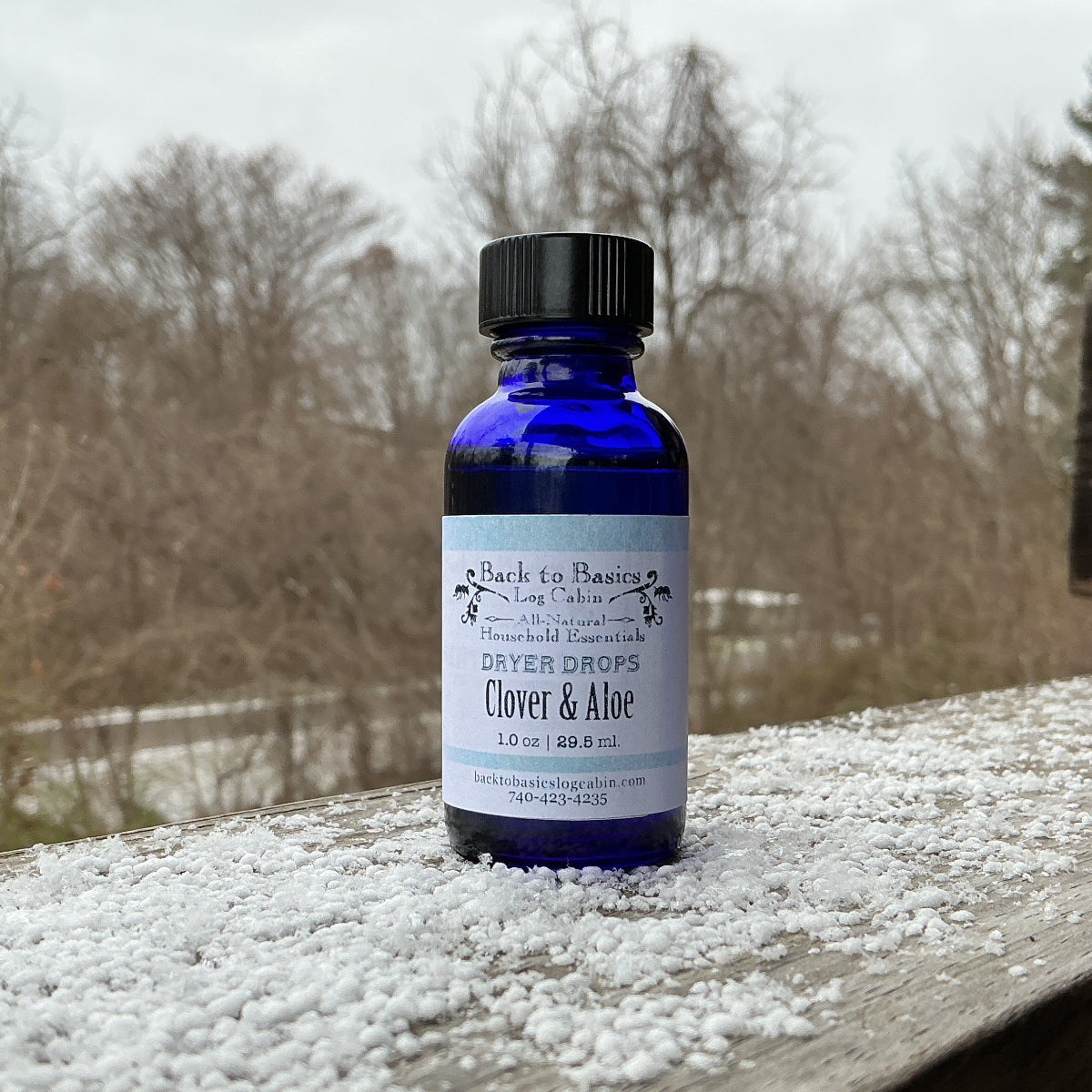 Bottle of Clover & Aloe product on a wooden surface with a snowy background