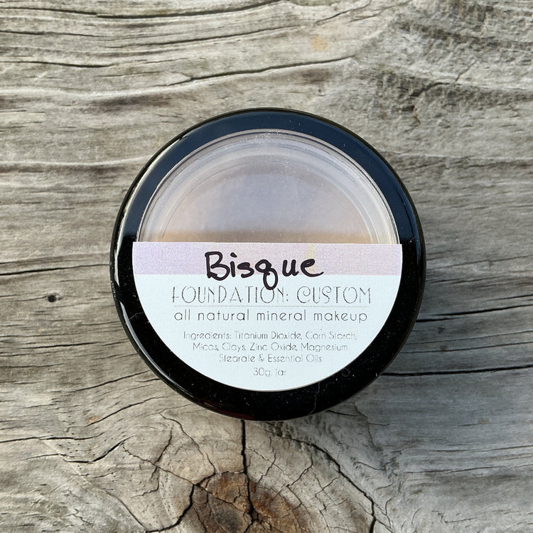 Bisque custom all natural mineral makeup container on a wooden surface