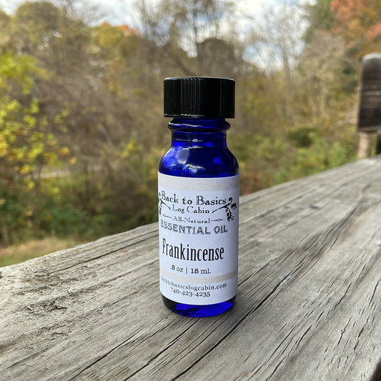 Bottle of Frankincense essential oil on a wooden surface with a natural background
