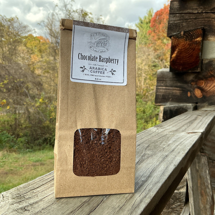Kraft paper coffee bag with a window showing coffee beans, labeled 'Chocolate Raspberry', on a wooden surface with a natural background.