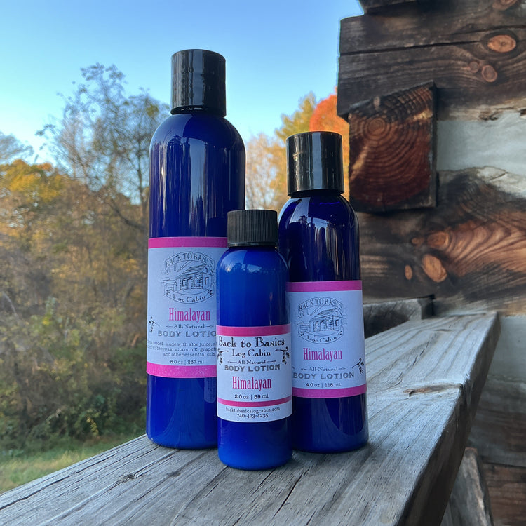Three blue bottles with black caps on a wooden surface outdoors.