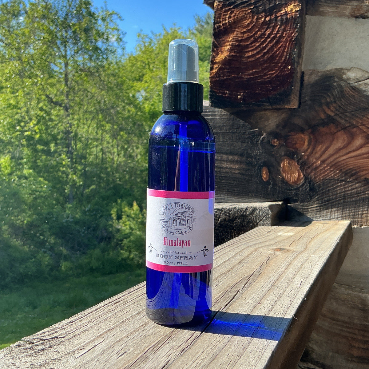 Blue spray bottle with a label on a wooden surface outdoors