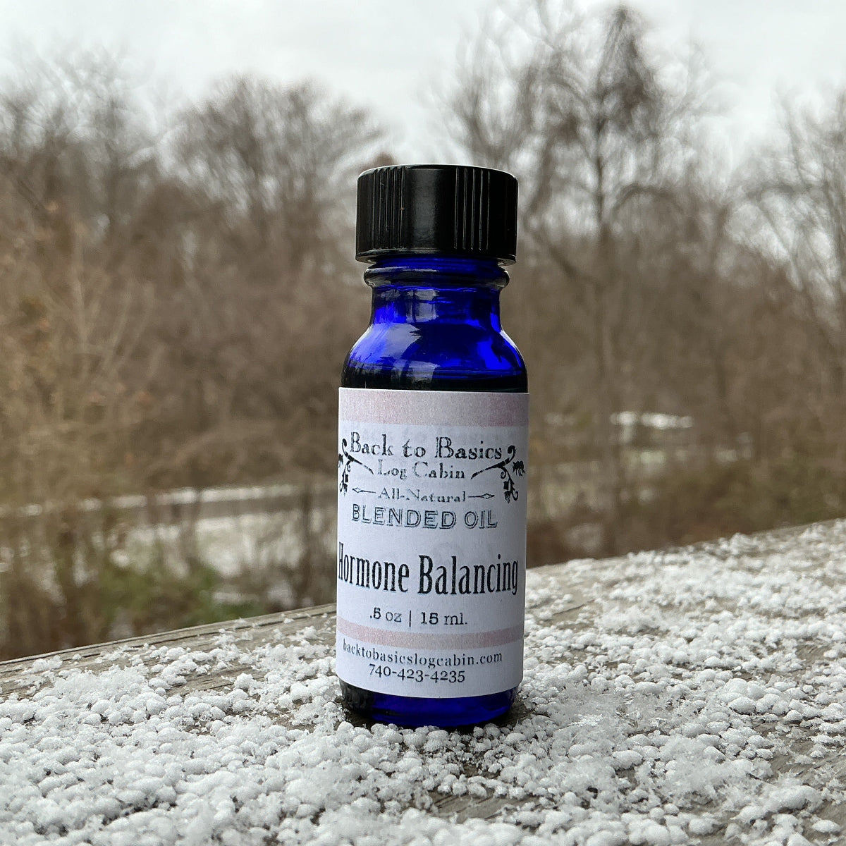 Bottle of Blended Oil on a snowy surface with a blurred natural background