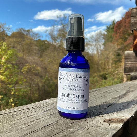 Blue bottle of facial hydrosol with a label on a wooden surface outdoors