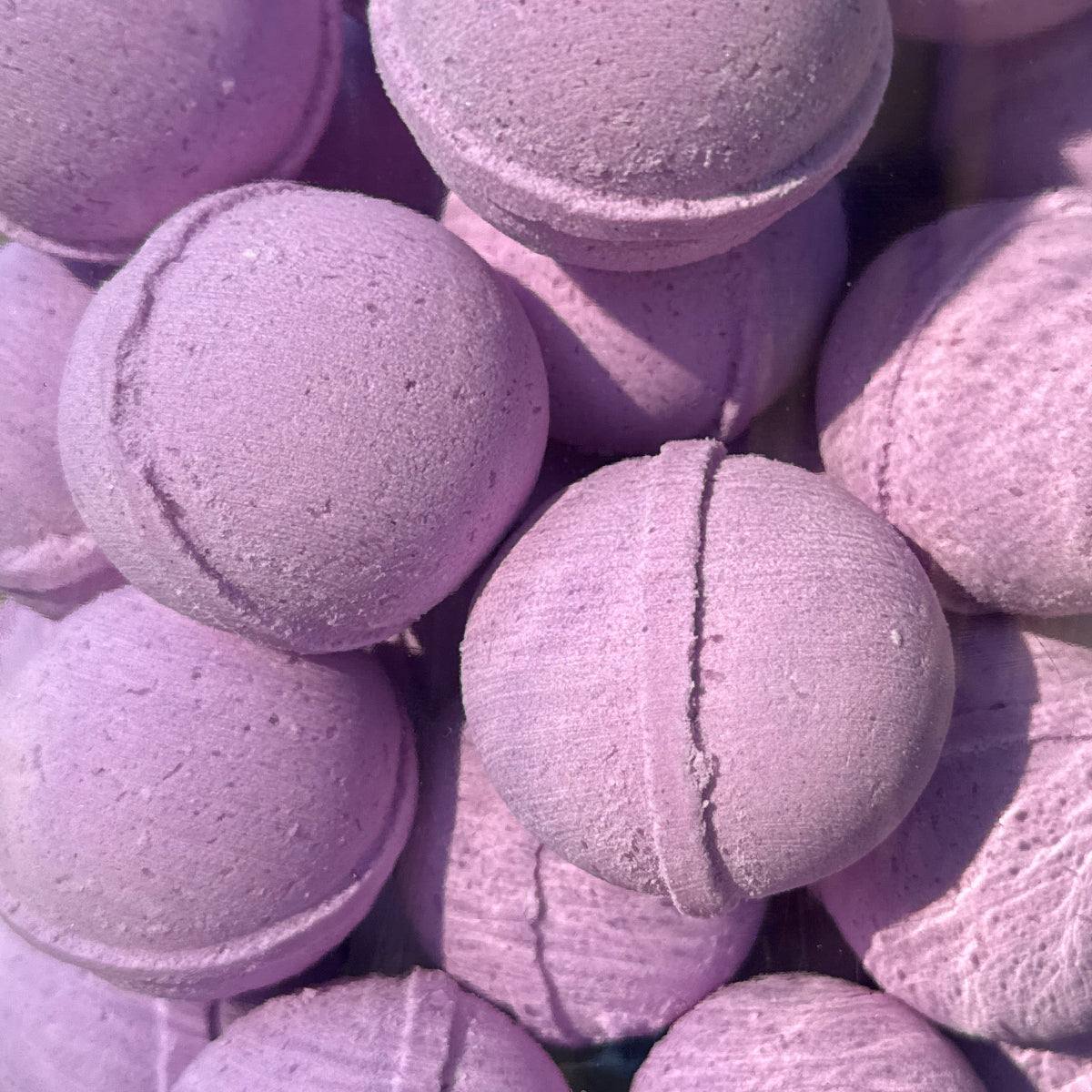 Jar filled with purple bath bombs on a wooden surface