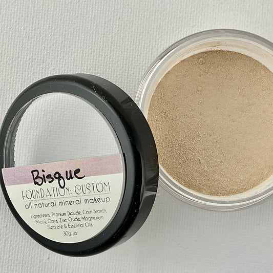 Open container of Bisque Foundation Custom mineral makeup on a light gray background