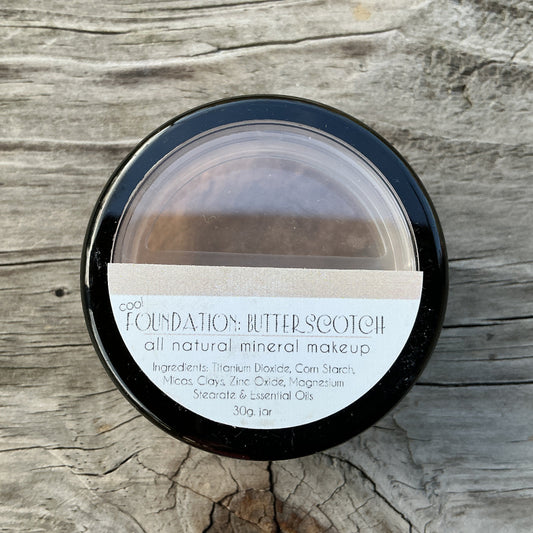 Jar of 'Butterscotch' foundation on a wooden surface