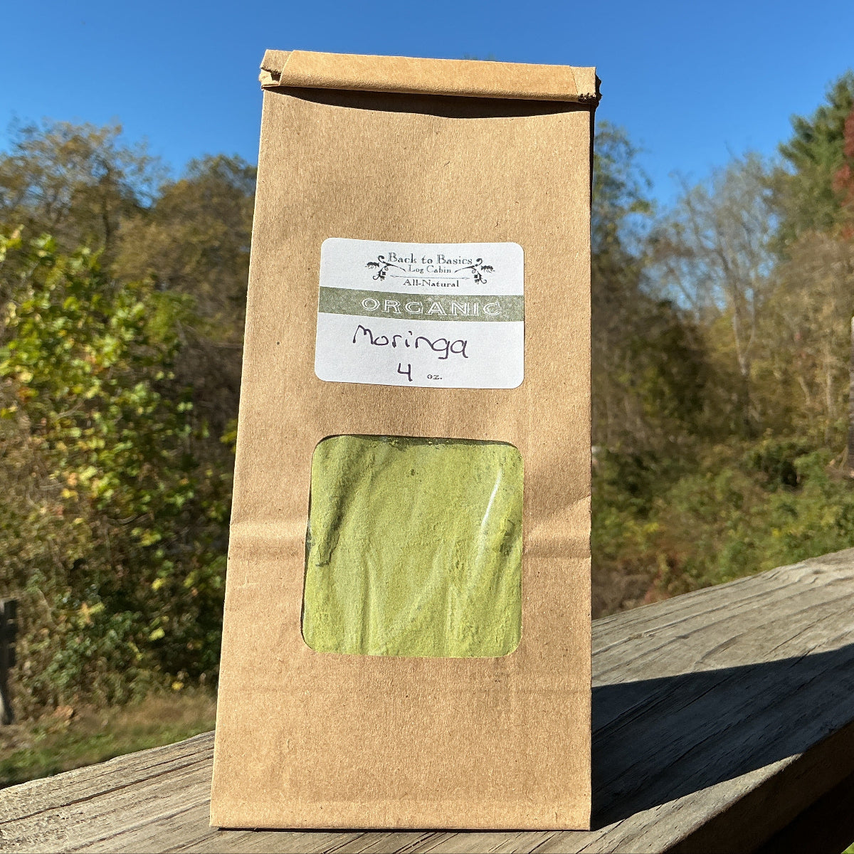 Brown paper bag with green product on a wooden surface outdoors