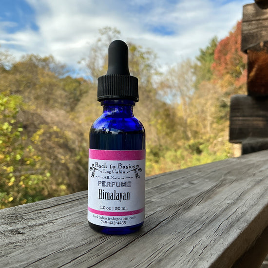 Perfume bottle labeled 'Himalayan' on a wooden surface with a scenic background