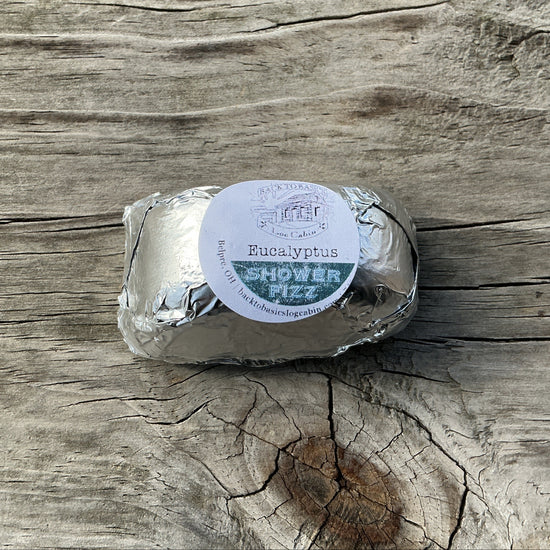 Shower puff wrapped in silver paper on a wooden surface
