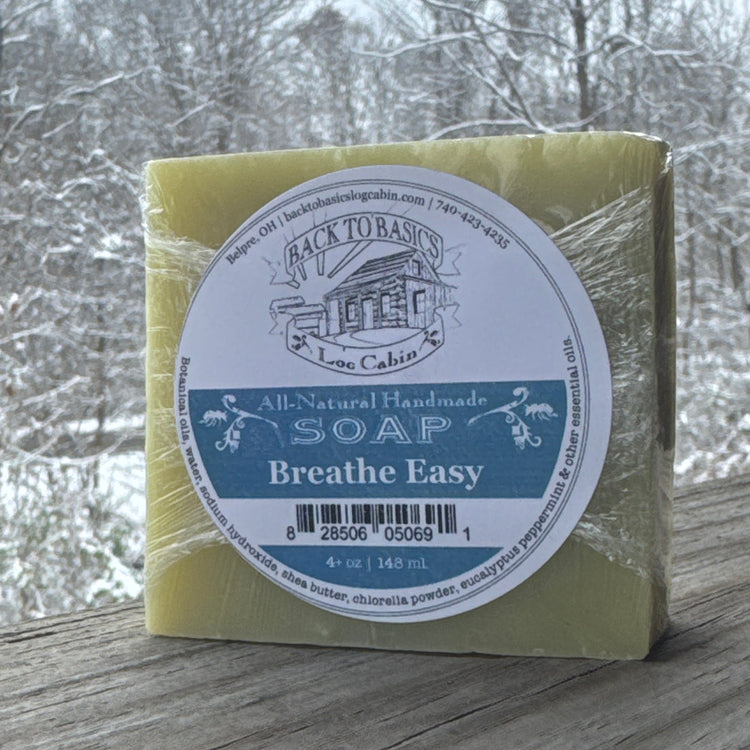 Bar of soap with a label on a wooden surface and blurred natural background