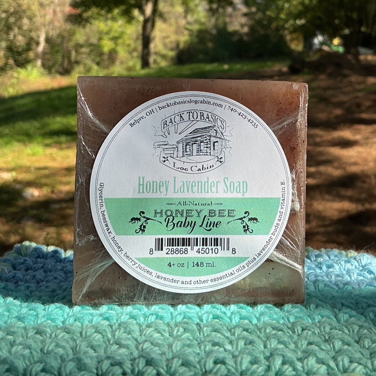 Bar of soap with a label on a green knitted blanket outdoors