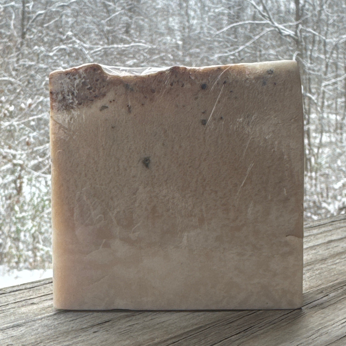 Brown rectangular object with a small black mark on a light gray background