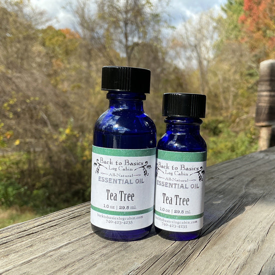 Two bottles of tea tree essential oil on a wooden surface with a natural background