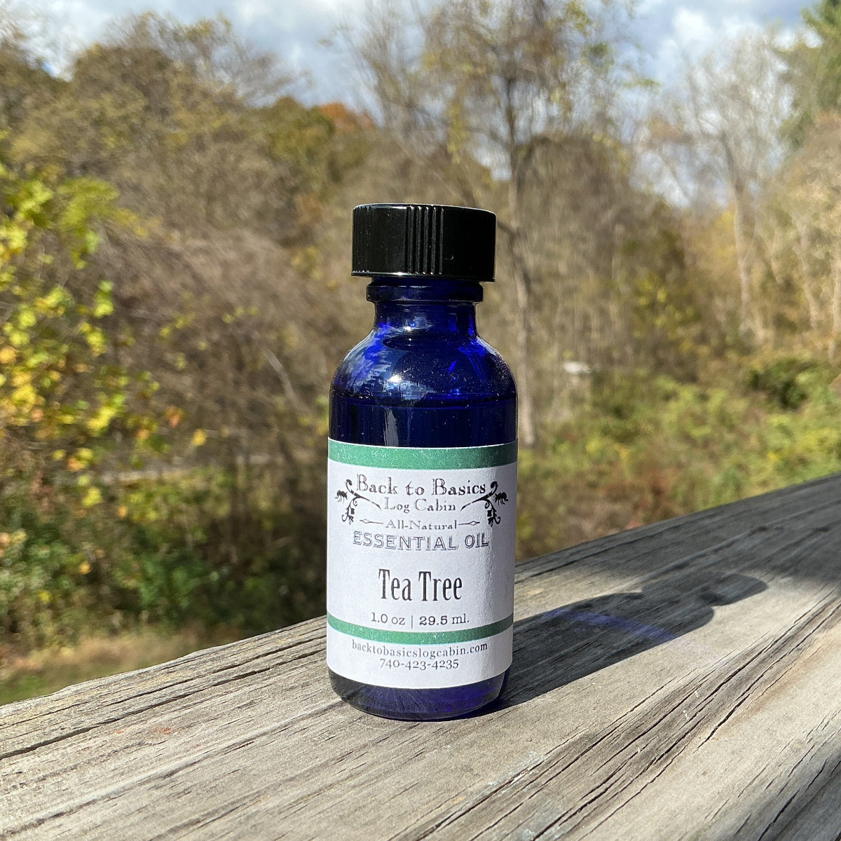 Blue bottle of Tea Tree oil on a wooden surface with a natural background