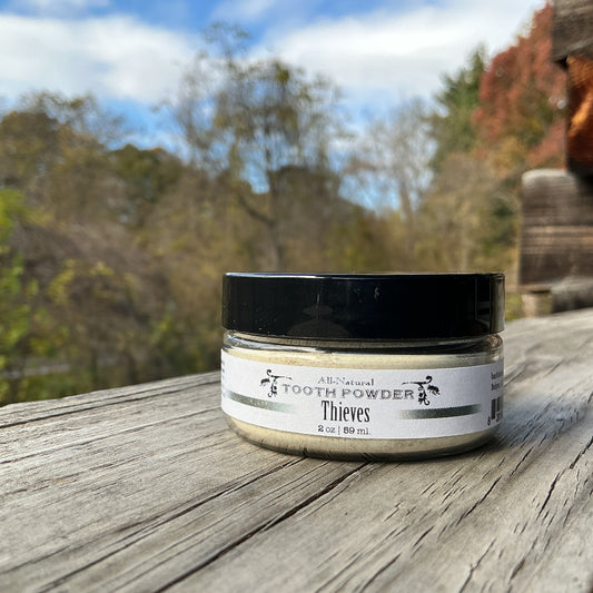 Jar of tooth powder on a wooden surface with a natural background